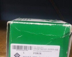 A green box with a label on it sits on a shelf.